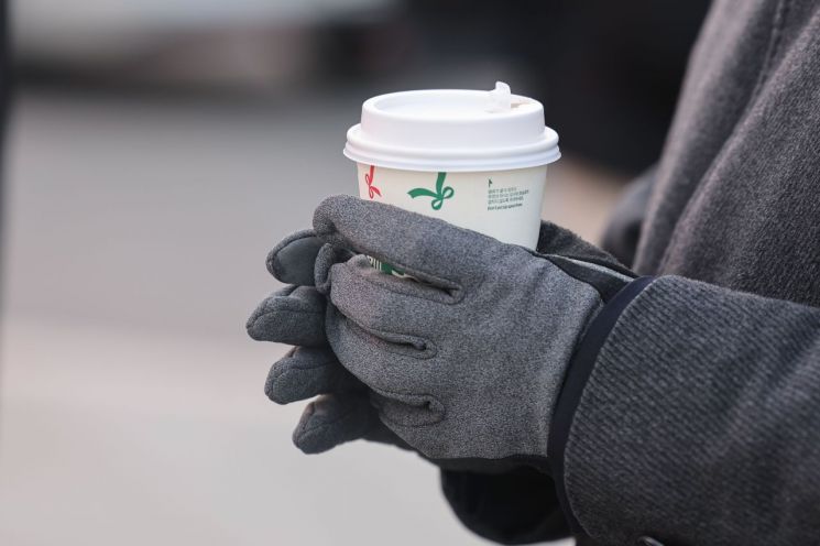 서울 종로구 광화문네거리에서 한 시민이 따뜻한 커피를 손에 들고 있다.연합뉴스