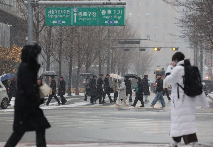 이달 12일 서울 종로구 종각역 인근에서 시민들이 눈을 맞으며 이동하고 있다.연합뉴스