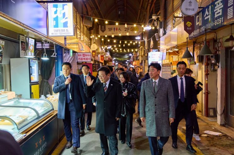 이재명 대통령이 9일 저녁 식사를 위해 방문한 서울 종로구 통인시장에서 상인들에게 인사하고 있다. 연합뉴스