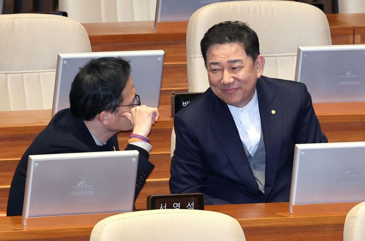 무소속 김병기 의원(오른쪽)과 더불어민주당 박주민 의원이 10일 국회 본회의장에서 열린 경제 분야 대정부질문에서 얘기를 나누고 있다. 연합뉴스