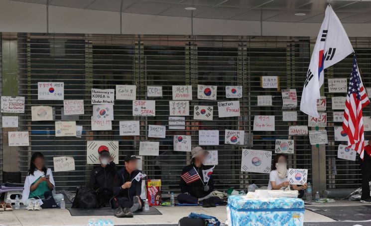 개표소 봉쇄 시위가 이어진 10일 서울 송파구 올림픽공원 핸드볼경기장 앞에서 시위대가 손팻말과 태극기를 들고 있다. 연합뉴스