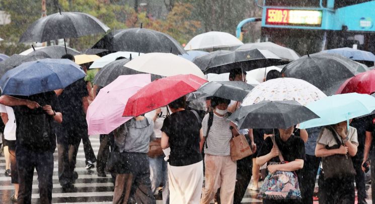 서울 광화문역 인근에서 시민들이 우산을 쓰고 길을 건너고 있다.연합뉴스