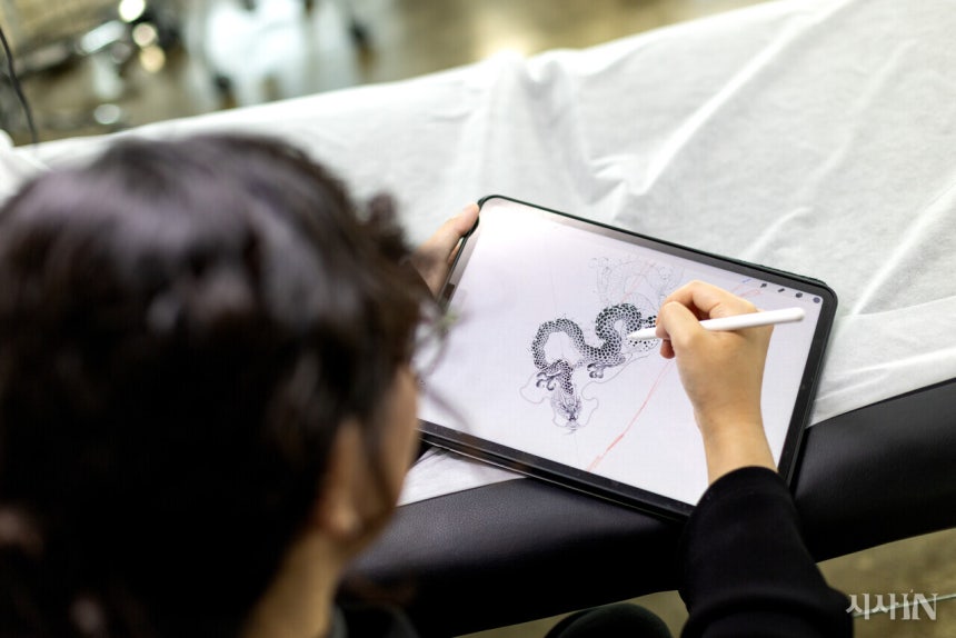 황도씨가 태블릿 PC로 타투 도안을 그리고 있다.그는 아주 가는 선으로 이루어진 섬세하고 정교한 스타일의 타투를 하는‘파인라인 타투이스트’다.©시사IN 신선영