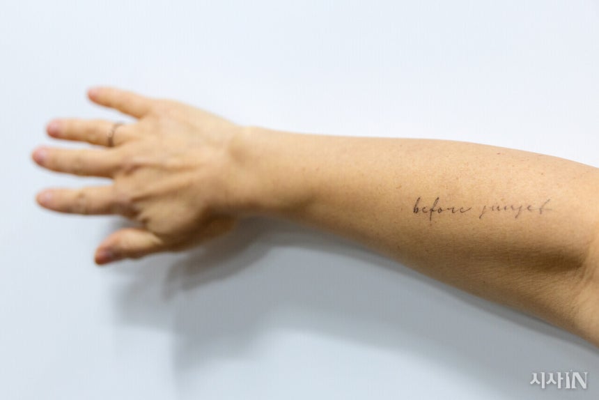 은유 작가가 오른팔에 새긴 레터링 타투. ‘비포 선셋’은 글쓰기의 시작을 떠올리게 하는 문구다. ©시사IN 신선영