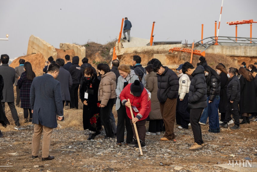 제주항공 참사 1주기인 지난해 12월29일 무안공항에서 열린 추모식을 마친 유가족들이 공항 활주로 남측 끝 콘크리트 둔덕을 둘러보는 모습. 일부 유가족은 울먹이며 참사 현장 바닥을 살펴보고 있다. ©시사IN