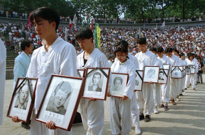 1994년 6월11일 한양대 노천극장에서 열린 《민족민주 열사 범국민추모제 및 6월항쟁 기념대회》에서 유가족과 학생들이 민주화과정에서 숨진 민주열사들 1백16명의 영정을 들고 식장으로 들어서고 있다. ©연합