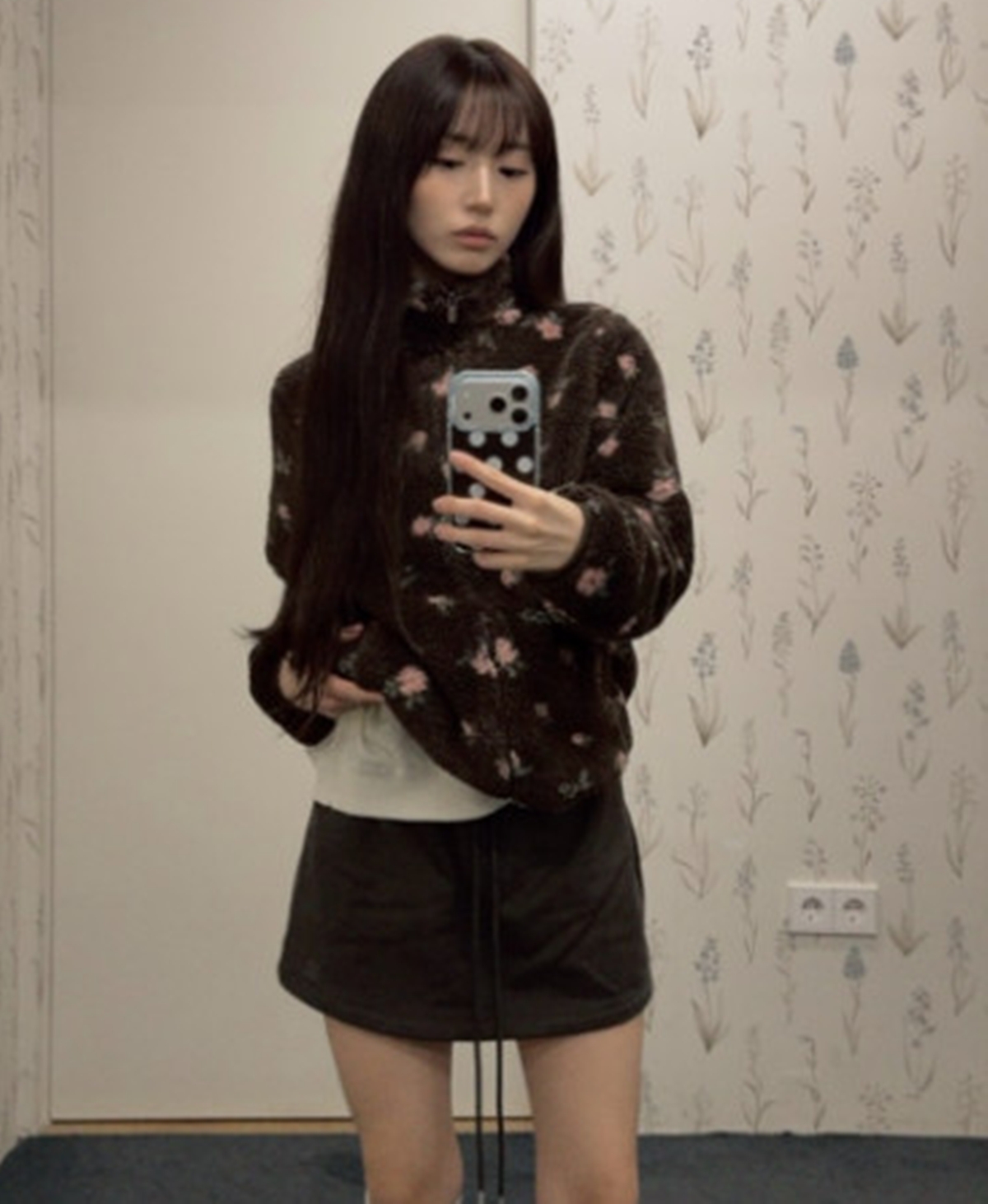 NMIXXの公式SNSで公開された、花柄のフリースとミニスカート姿のヘウォンの写真