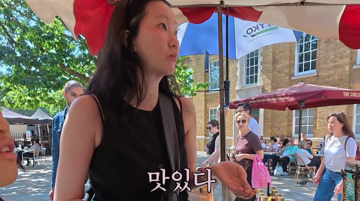 ロンドンのマーケットで買い物をするチャン・ユンジュ。画面には韓国語で「おいしい」と表示されている