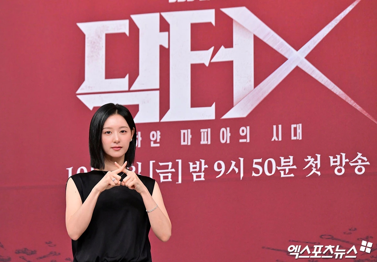 ドラマ『ドクターX』の背景の前に立つキム・ジウォン
