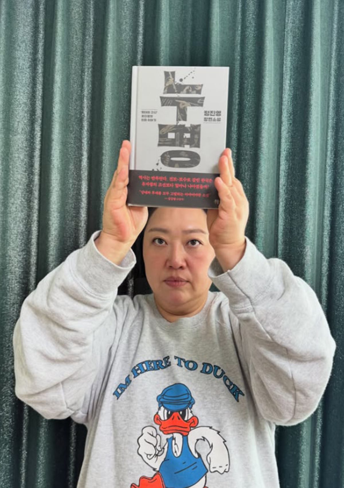 夫チョン・ジニョンの小説『ヌミョン』を頭上に掲げるパク・ジュンミョン。