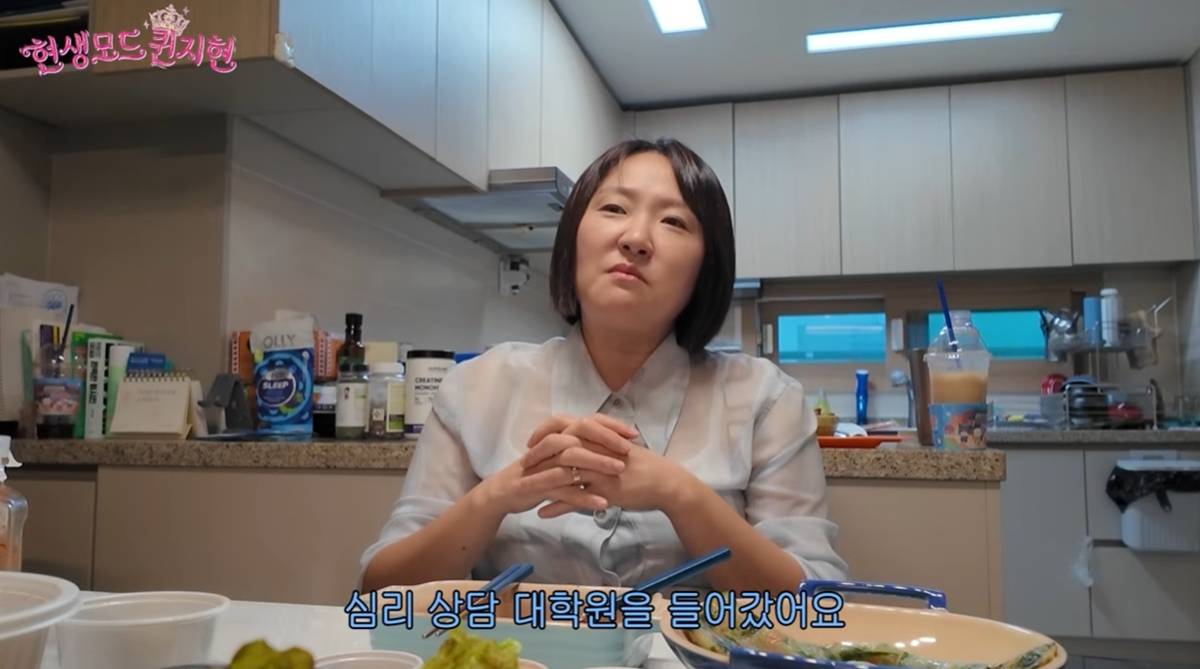 YouTube「현생모드퀸지현」の動画で、食卓に座るキム・ヒョンスク。字幕に「心理相談大学院に入った」と表示されている