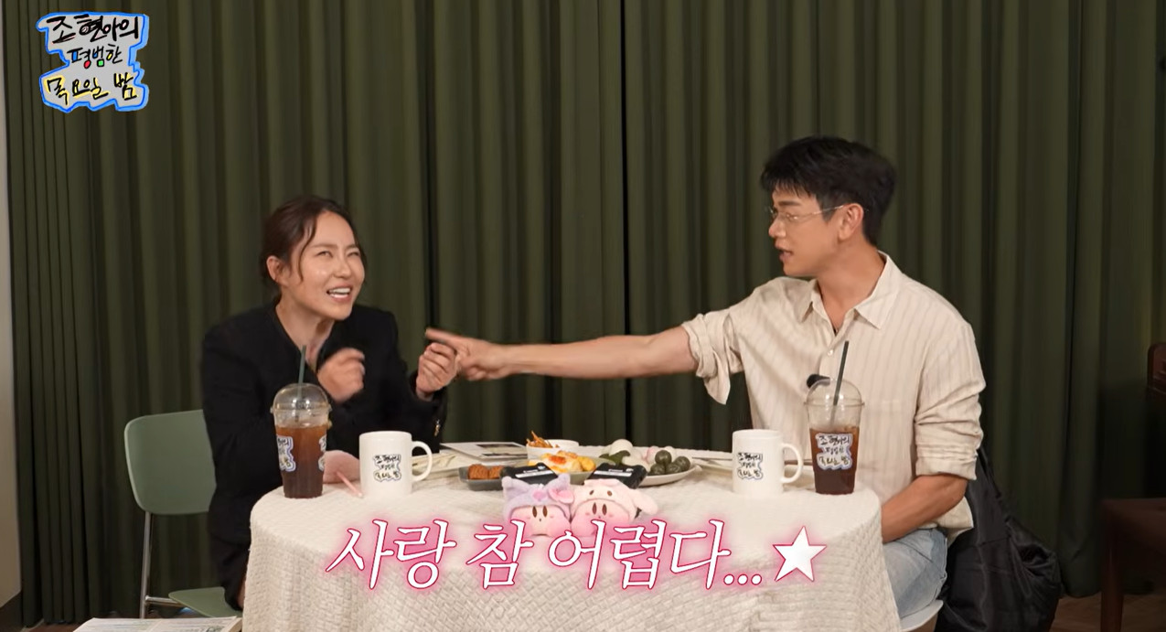 YouTube「조현아의 평범한 목요일 밤」の画面。テーブルを挟んで話すチョ・ヒョナとエリック・ナム。字幕に「愛は本当に難しい」とある。