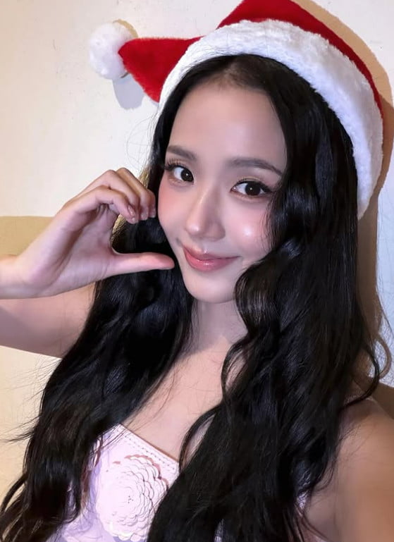 Jisoo posing in pink Christmas outfit