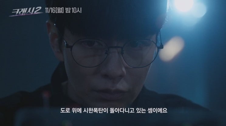 暗い道路を背景に、眼鏡をかけた人物が映る『クラッシュ2』のティザー映像