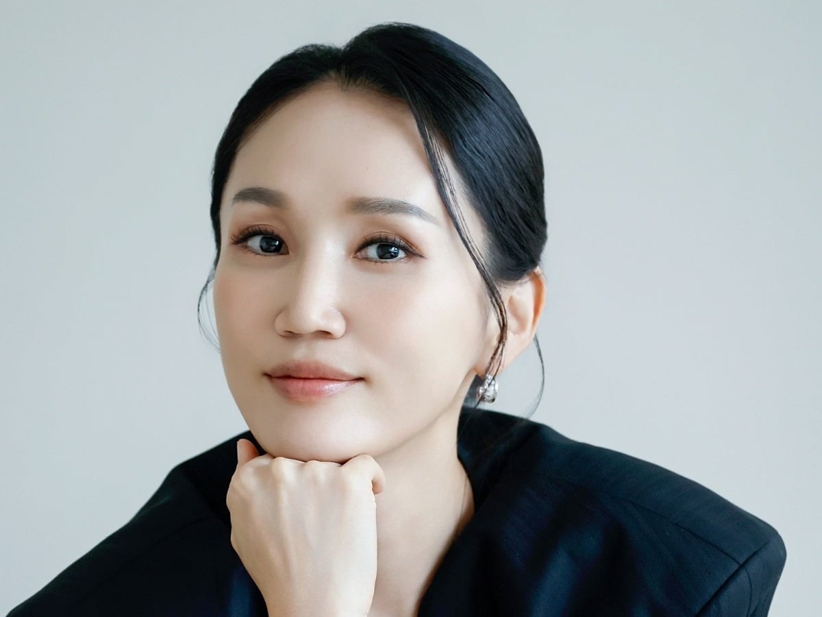 黒い衣装で頬杖をつき、カメラに微笑む俳優パク・ボギョン