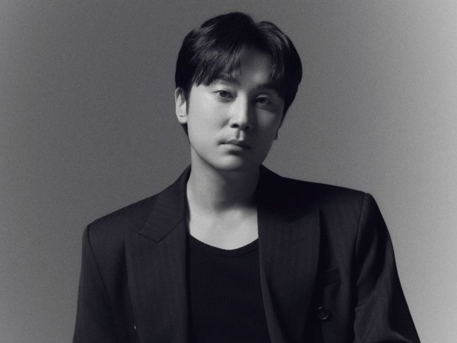黒いジャケットを着て正面を見つめる俳優ソ・ヒョヌのモノクロポートレート