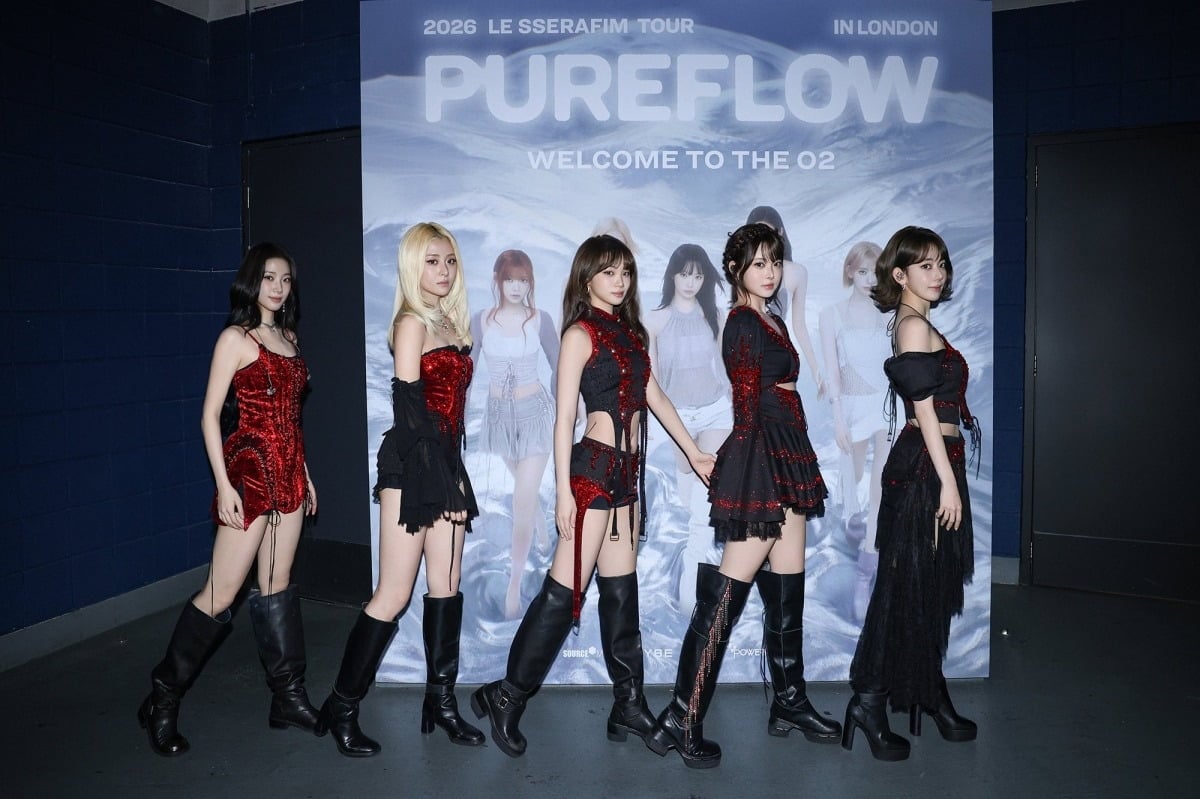 ロンドン公演の「PUREFLOW」看板の前に並ぶLE SSERAFIMの5人