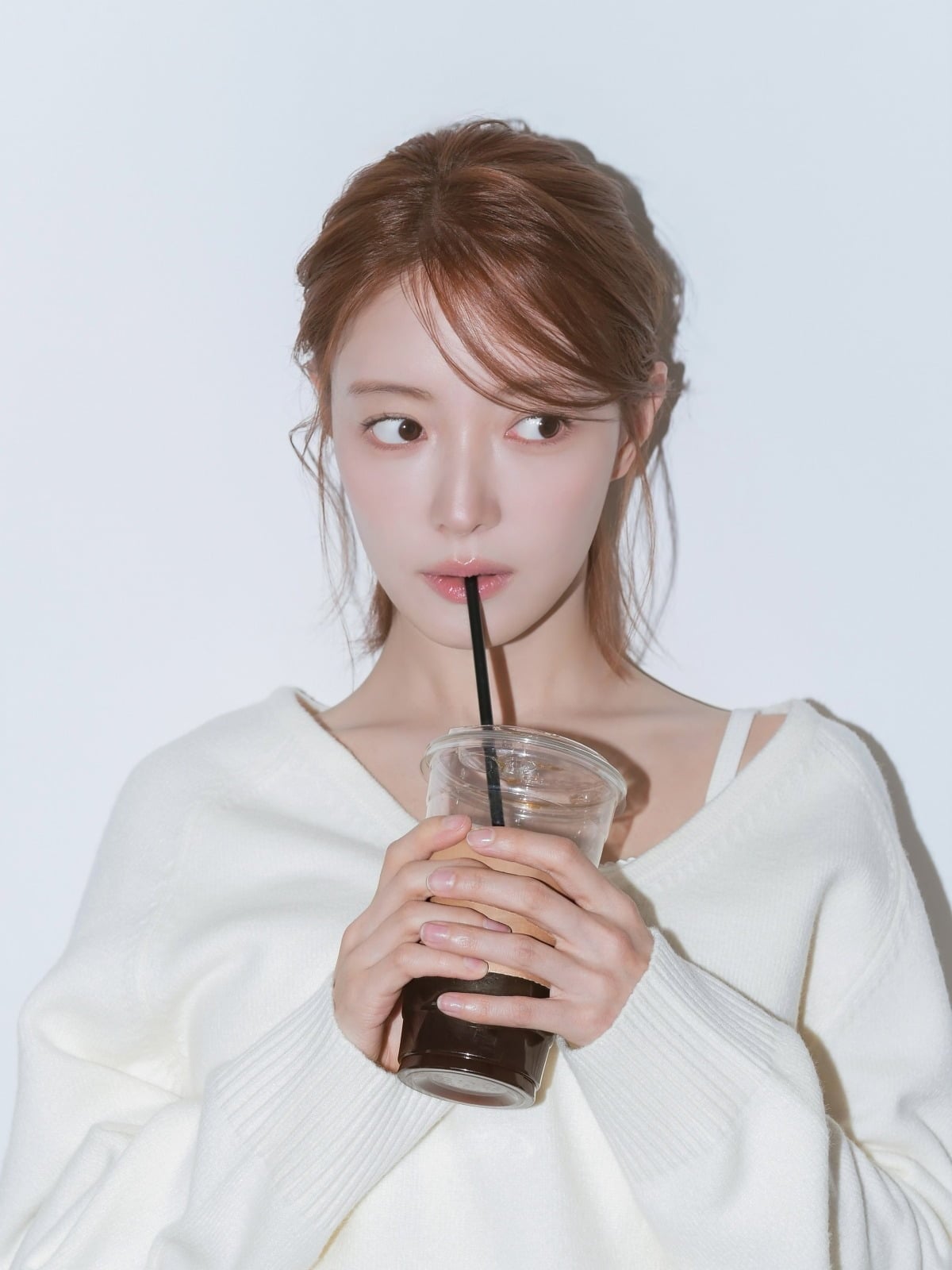 白いニットを着たイ・セヨンがアイスコーヒーを手に持つ写真
