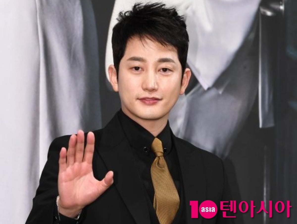 黒いスーツ姿で手を上げてあいさつする俳優パク・シフ