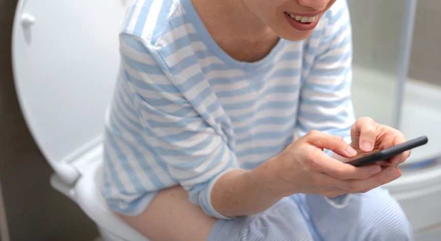 배변을 마친 뒤 변기에 앉아 스마트폰이나 책을 보는 습관은 고치는 게 좋다./사진=게티이미지뱅크