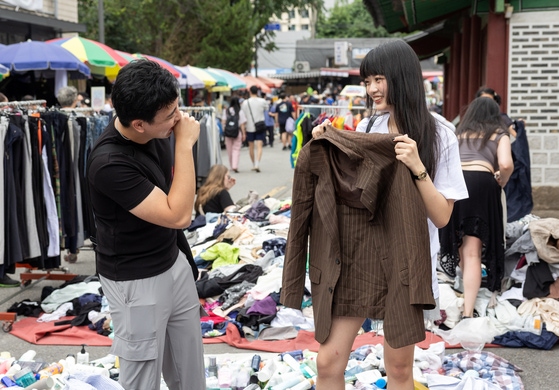 지난달 22일 서울 동묘 구제시장을 찾은 MZ세대 커플이 옷을 고르고 있다. 최기웅 기자