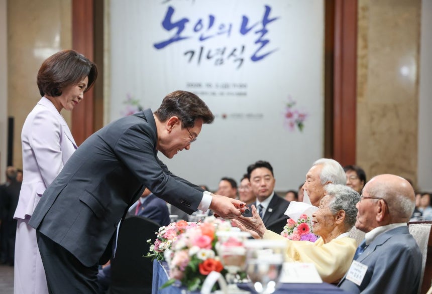 이재명 대통령이 2일 서울 한 호텔에서 열린 노인의 날 기념식에서 100세 어르신들에게 장수를 기원하는 지팡이 '청려장'을 전달하고 있다. [뉴스1]