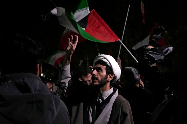  A cleric chants slogans during an anti-Israeli gathering in front of the British Embassy in Tehran, Iran, early Sunday,
