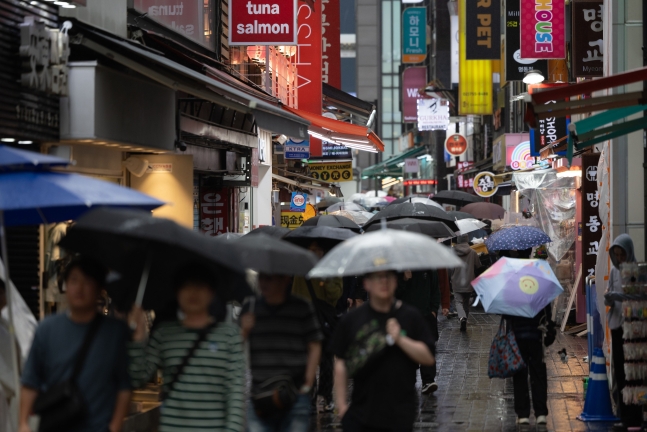 전국에서 비가 내린 지난 15일 오후 서울 중구 명동거리에서 외국인 관광객들이 발걸음을 재촉하고 있다. /뉴스1
