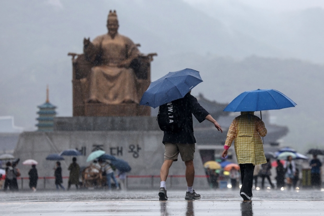 어린이 날을 맞은 5일 서울 종로구 광화문광장에서 우산을 쓴 가족 나들이객이 쏟아지는 빗속에 걸음을 옮기고 있다. /뉴스1
