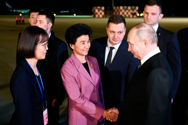 중국을 국빈 방문 중인 블라디미르 푸틴 러시아 대통령(오른쪽)이 17일 하얼빈 공항에 도착해 관계자들의 환영을 받고 있다. /AP 연합뉴스