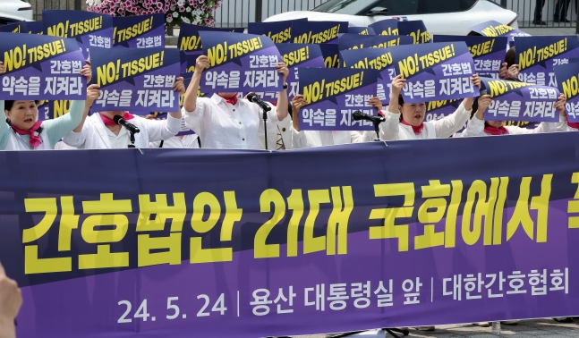 (대한간호협회 소속 간호사들이 24일 오전 서울 용산 대통령실 앞에서 간호법안 제정을 촉구하며 단체로 팻말을 들고 있다./뉴스1