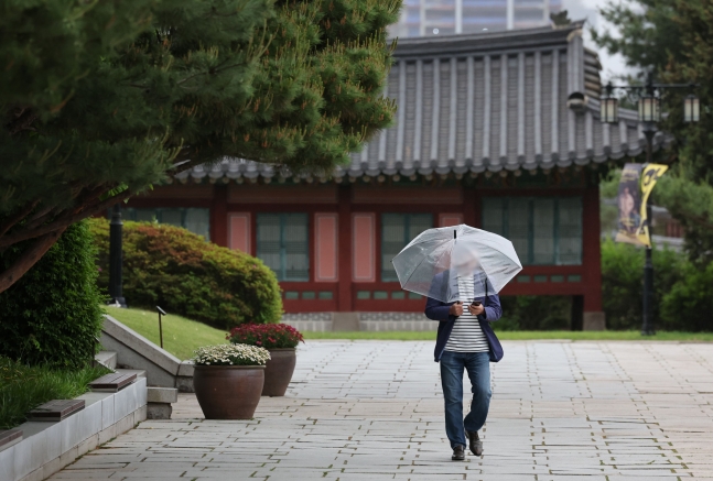 수도권 지역에 비가 내리는 지난 15일 오후 서울 종로구 국립민속박물관에서 우산을 쓴 관람객들이 발걸음을 옮기고 있다./뉴스1