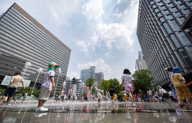 夏季夏天的早晨，訪問了Jongno -Gu的Gwanghwamun廣場噴泉的孩子正在冷卻熱量。
