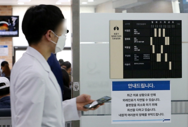 대전에 위치한 종합병원 진료과 입구에  진료 지연 안내문 앞으로 의료진이 이동하고 있다./뉴스1