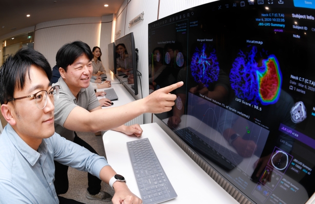 제이엘케이 직원들이 뇌졸중 진단 AI를 실행한 컴퓨터 화면을 보며 이야기 나누고 있다./조선비즈