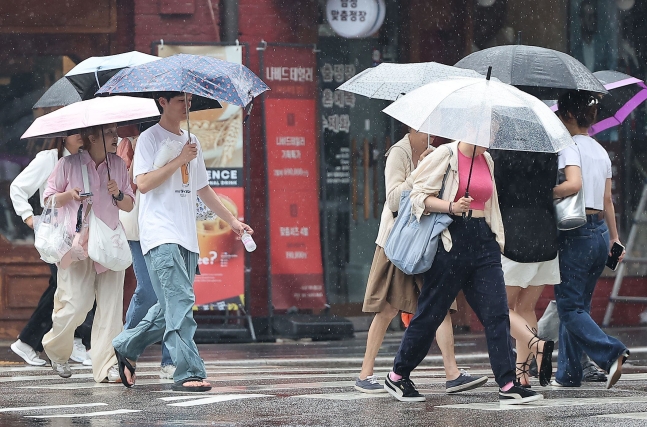 22일 서울 종각역 인근에서 시민들이 우산을 쓰고 이동 중이다. 월요일인 24일에는 새벽부터 비가 내리다가 점차 그치겠다./뉴스1