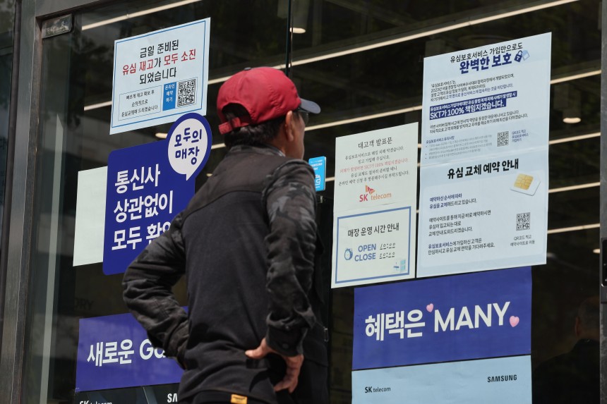 SK텔레콤이 가입자 유심(USIM) 정보 유출 사태로 오는 5일부터 신규 가입자 모집을 중단한다고 밝힌 2일 서울 시내의 한 SK텔레콤 대리점 앞에서 한 소비자가 유심 재고 소진 및 유심보호서비스 관련 안내문을 살펴