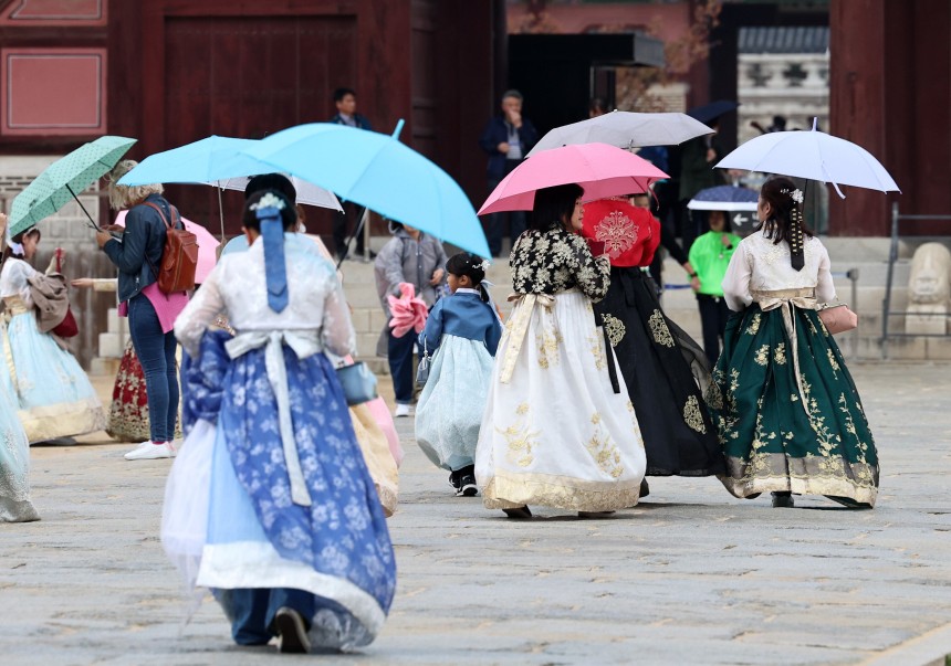 서울 종로구 경복궁에서 한복을 입은 관광객들이 우산을 쓰고 나들이를 즐기고 있다./뉴스1