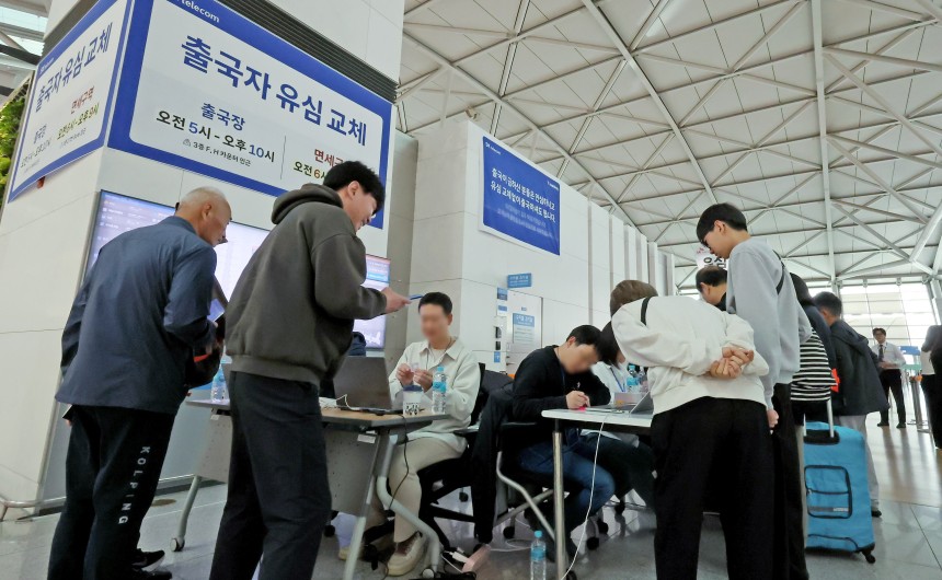 6일 오전 인천국제공항에 설치된 SKT 부스를 찾은 여행객들이 출국에 앞서 유심을 교체하고 있다./뉴스1