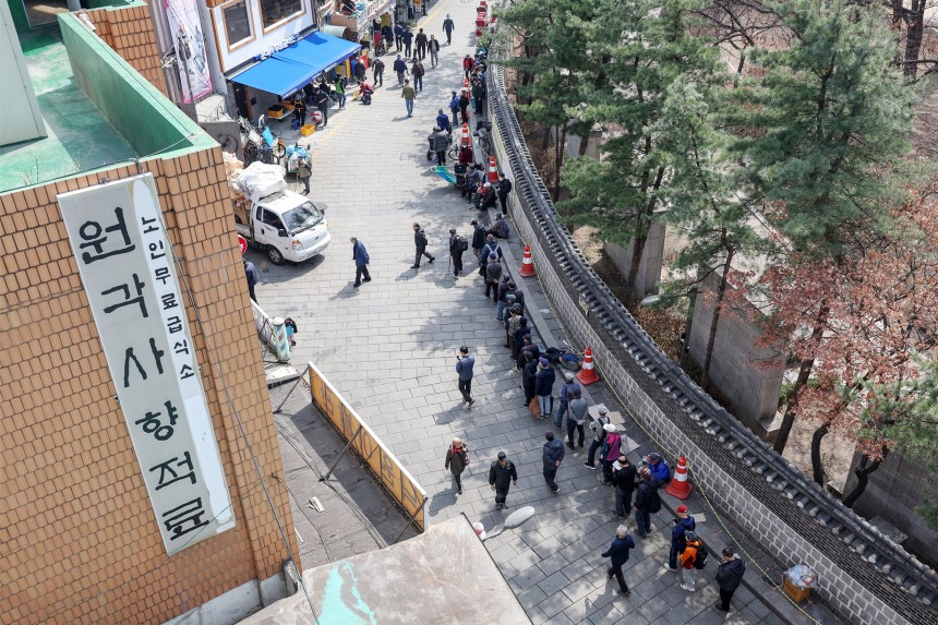 서울 종로구 탑골공원 인근 무료급식소 앞에 어르신들이 길게 줄을 서 식사 차례를 기다리고 있다./뉴스1