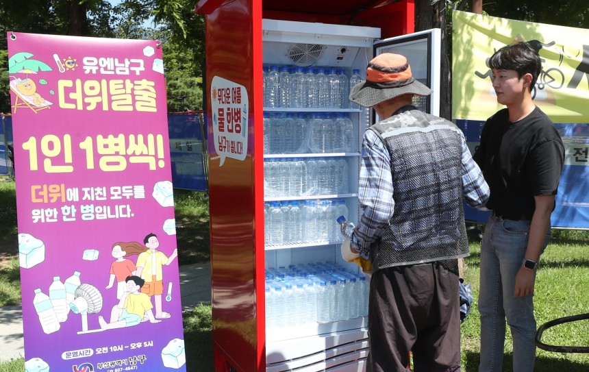 2024년 7월 31일 부산 남구 평화공원 내 생수냉장고가 설치돼 더위에 지친 시민들이 생수를 꺼내고 있다. /조선DB