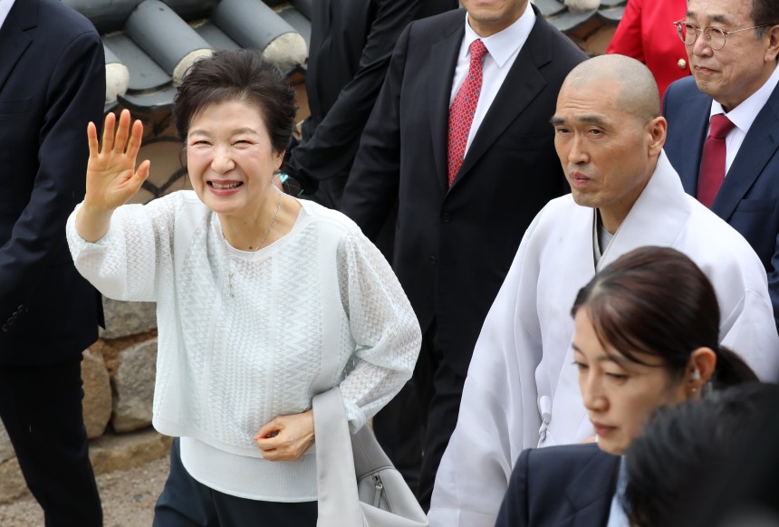박근혜 전 대통령이 2일 부산 금정구 범어사를 방문해 주지 정오스님과 대웅전으로 향하며 지지자들에게 인사하고 있다. /뉴스1