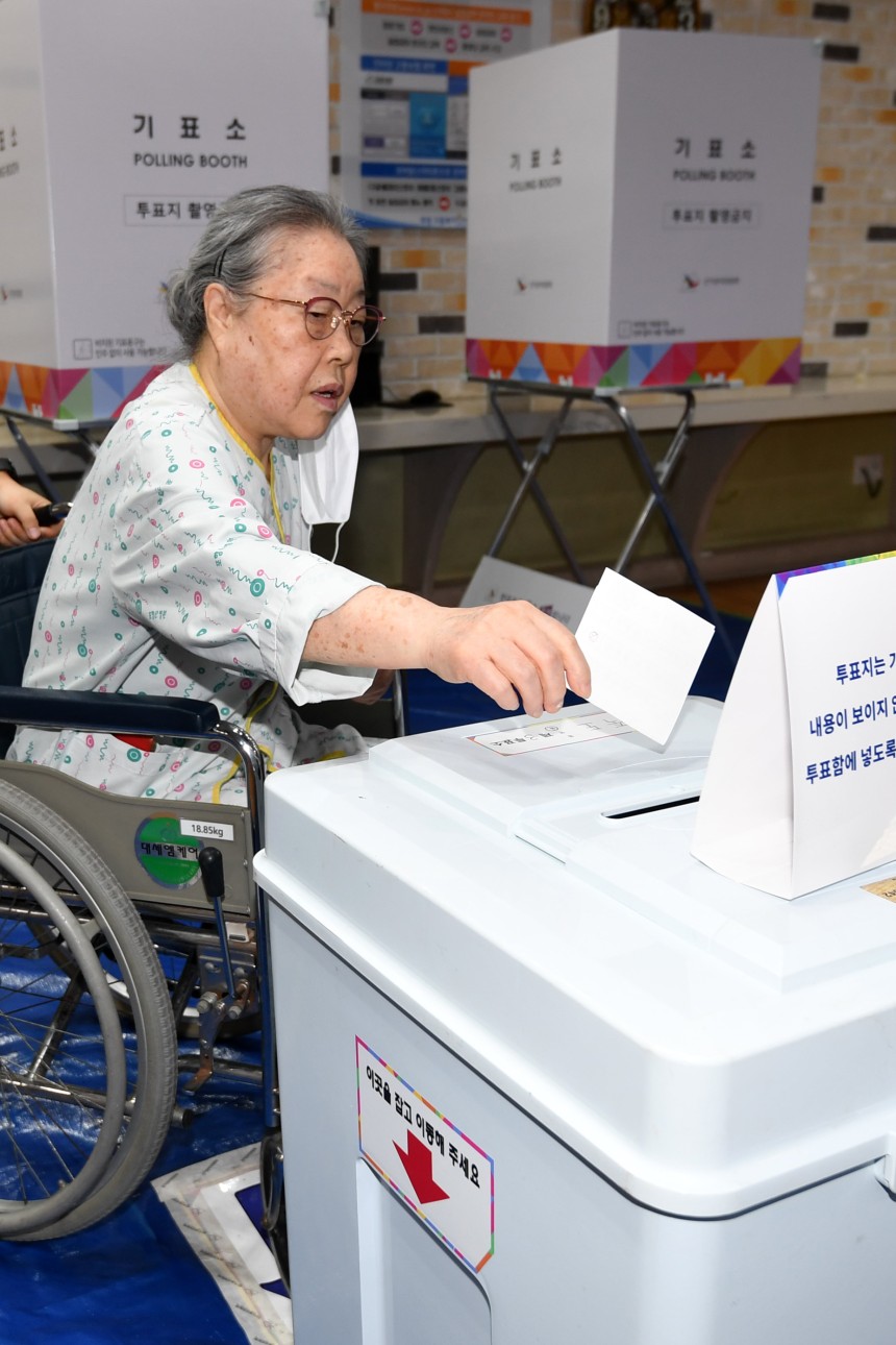 제21대 대선 본투표날인 3일 경북 포항시 북구 죽도동 포항고용복지센터에 마련된 투표소에서 요양병원에 입원 중이던 이 모(74)씨가 투표사무원의 도움을 받아 소중한 한표를 행사하고 있다. /뉴스1