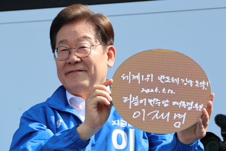 이재명 대통령이 지난달 12일 경기 화성시 동탄 센트럴파크 음악분수중앙광장에서 '세계 1위 반도체 강국 도약!'이라고 쓴 반도체 웨이퍼를 들어 보이고 있다./공동취재단 