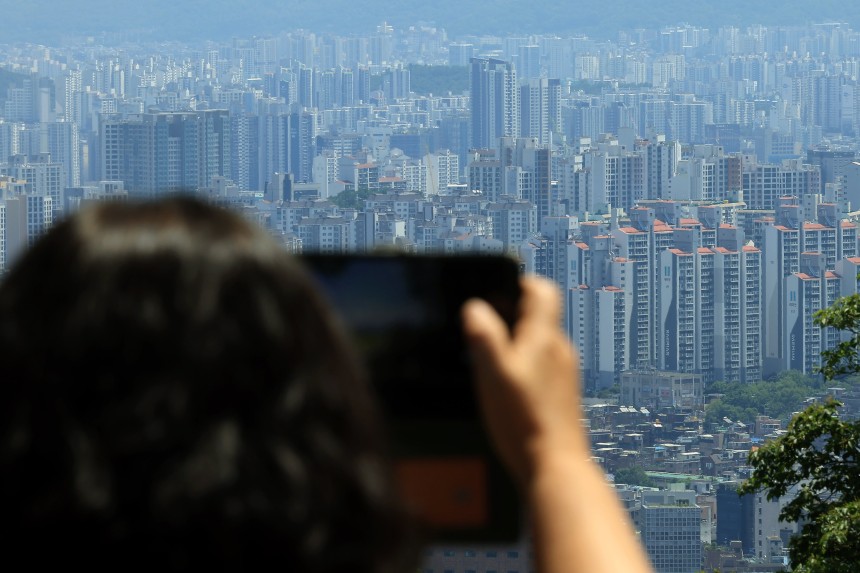 지난 12일 서울 남산을 찾은 시민이 도심 아파트단지 등을 촬영하고 있다. /뉴스1