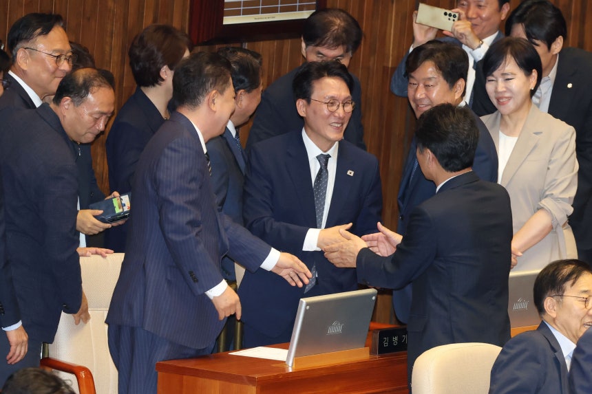 김민석 국무총리 후보자가 3일 오후 서울 여의도 국회에서 열린 본회의에서 국무총리 임명동의안이 가결되자 더불어민주당 의원들과 인사를 나누고 있다./뉴스1