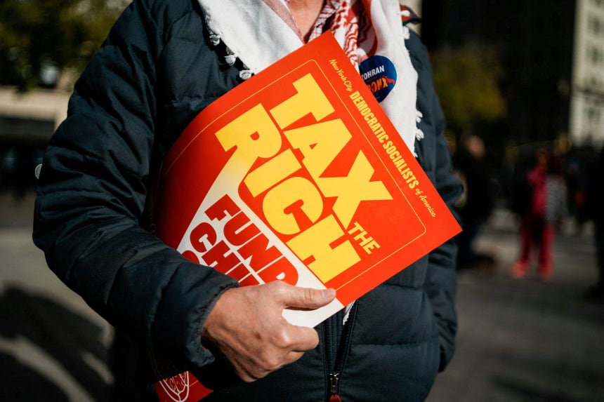 지난달 16일 미국 뉴욕에서 열린 '부자들에게 세금을 부과하라' 시위에 참여한 한 남성이 플래카드를 들고 서있다./연합뉴스