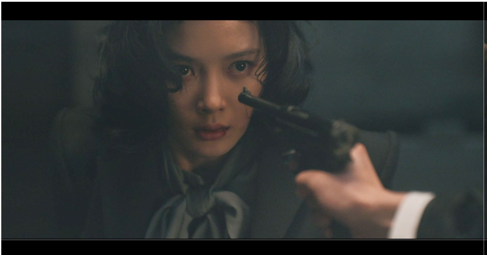 銃を構えるイ・ガギョンを演じるキム・ユジョン。ドラマ『100日の嘘』の場面写真