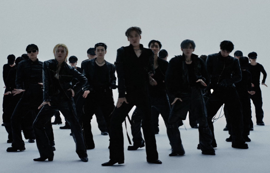 黒い衣装のATEEZメンバーとダンサーが並び、振り付けを披露する「Drip」のミュージックビデオ場面