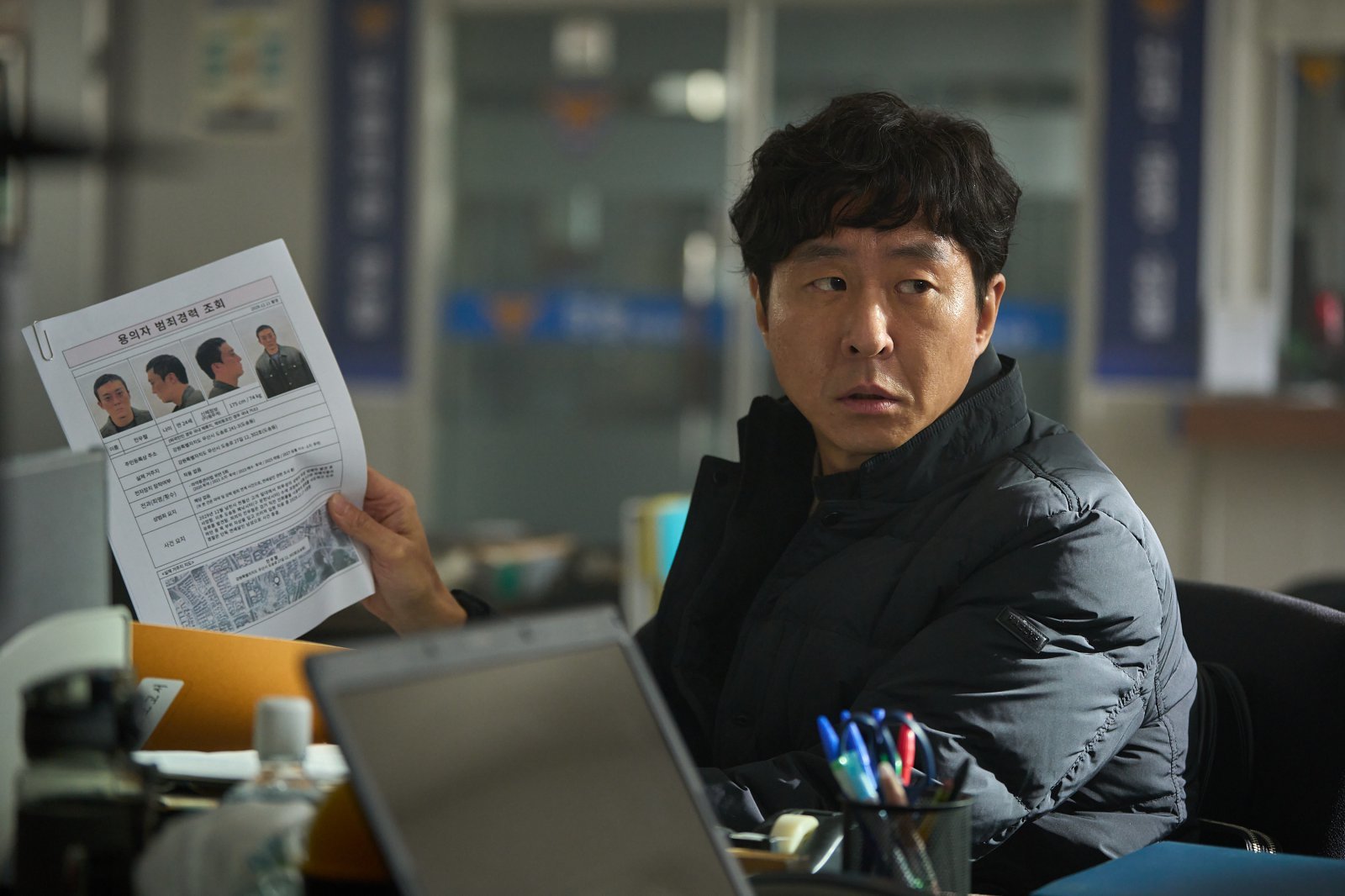 映画『失楽園』で事件を追う記者オ・ギョンウォンを演じるイ・ヒョンギュン。調査資料を手にしたスチール